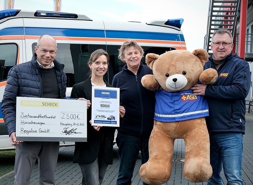 Das Bild zeigt den Geschäftsführer Marco Steffenmunsberg von Regiolux GmbH zusammen mit Mitarbeiterin Julia Stapf bei der Scheckübergabe an Andrea Bänker (ASB Wünschewagen Franken/Oberpfalz), Jochen Löser (ASB Würzburg-Schweinfurt)
